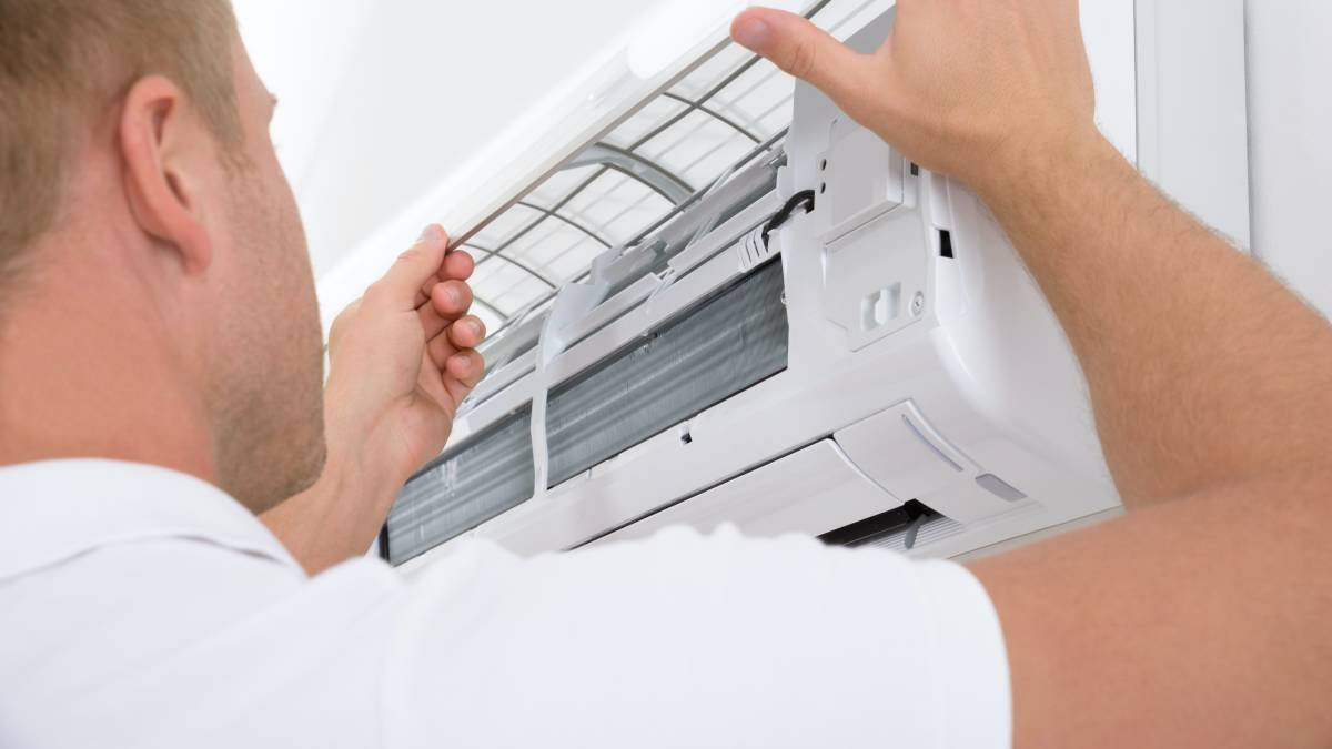 Portrait,Of,A,Young,Man,Adjusting,Air,Conditioning,System